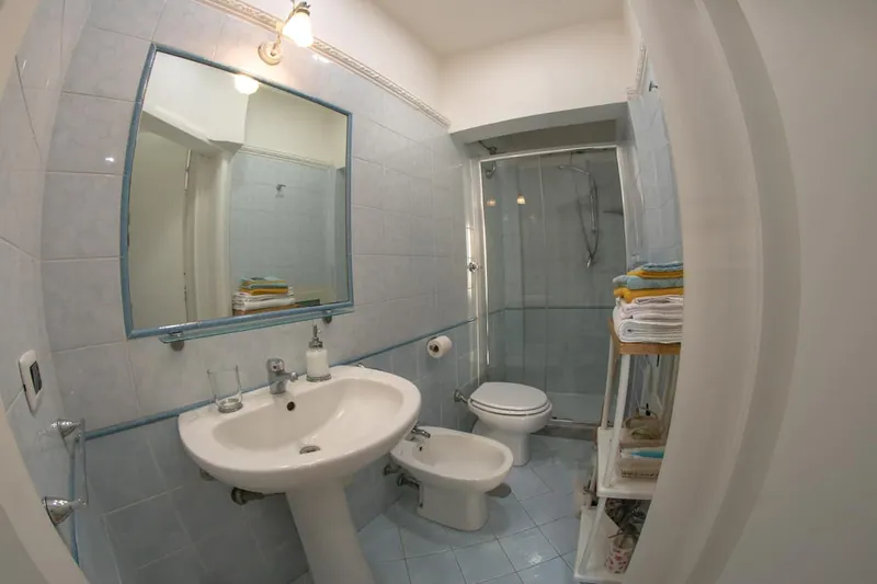 Il bagno: lo specchio, il lavabo e la doccia con i vetri.