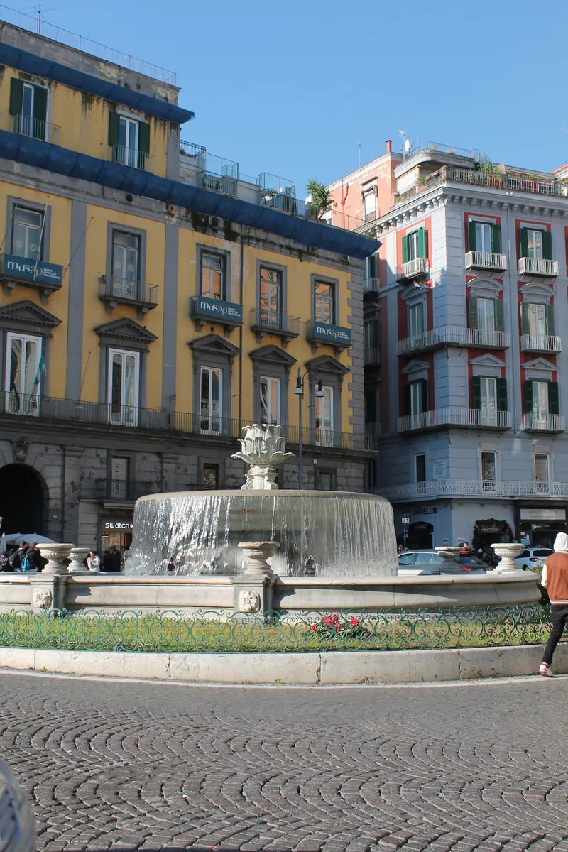 La fontana di piazza Trieste e Trento, con i palazzi gialli e rosa.
