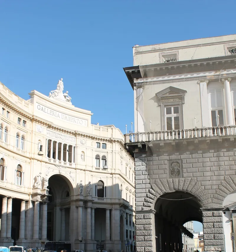 La Galleria Umberto I vista da fuori, con la scritta sulla facciata e il cielo azzurro.