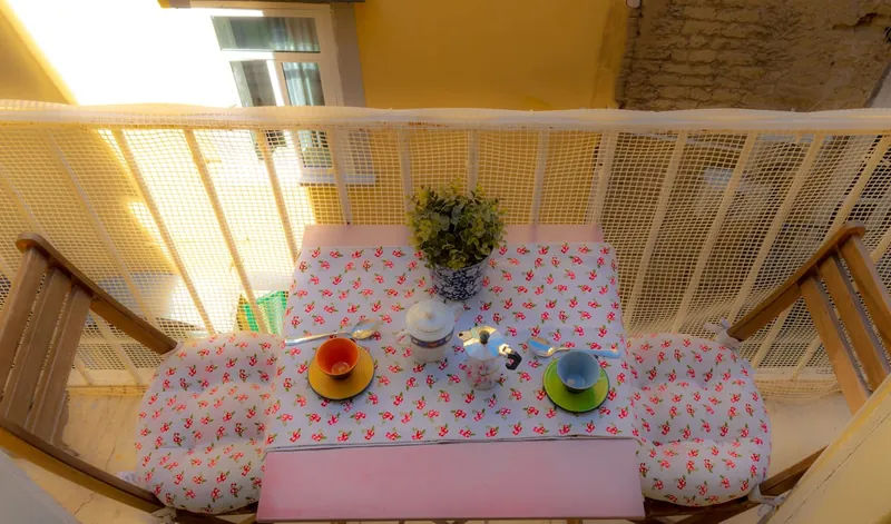 Il tavolino del balcone visto dall’alto, con le tazze colorate e la zuccheriera.